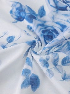 Close-up of mesh fabric texture featuring blue rose floral print on white dress material