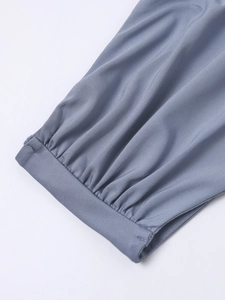 Detail of grey-blue dress showing pleated sleeve cuff and premium twill fabric texture