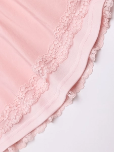 Close-up of pink dress hem featuring delicate double-layered floral lace embroidery and stitching