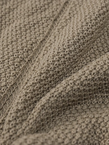 Macro shot of the khaki knitted fabric with a high-quality hollow-out texture
