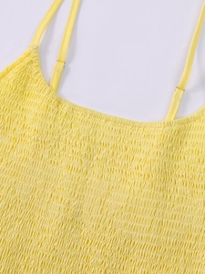 Detail of yellow smocking fabric with adjustable shoulder strap and metal buckle