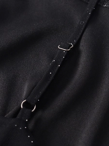 Détail de bretelles réglables noires avec anneaux métalliques et tissu pailleté discret