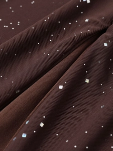 Gros plan détaillé du tissu en maille marron avec des paillettes carrées brillantes