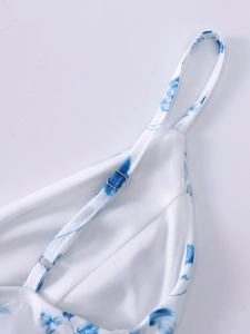 Detail of adjustable silver buckles and thin straps on a blue floral mesh fish-tail dress