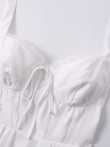 Dettaglio del bordo in pizzo bianco e fiocco con coulisse su un abito corto a trapezio