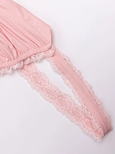 Macro detail of pink dress featuring delicate lace trim and pleated fabric texture