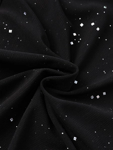 Dettaglio macro di tessuto a rete nero con paillettes argentate lucide e drappeggio
