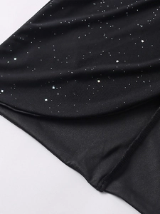 Détail du tissu en maille avec paillettes scintillantes et coutures sur une robe noire