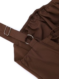 Detail of dark brown dress featuring adjustable shoulder straps and elastic ruched neckline