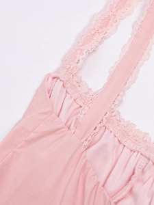 Detailed view of pink lace patchwork shoulder straps and soft knit fabric on a mini dress