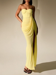 Détail d'une robe corset jaune clair en maille avec baleines et fente haute plissée