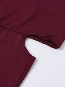 Détail de la robe bordeaux montrant les coutures de taille et la texture du tissu
