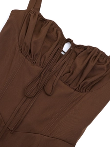 Detail of dark brown fishbone dress with pleated neckline and lace-up cutout design
