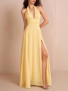 Detail des hohen Beinschlitzes und der Falten-Taille an einem gelben Neckholder-Maxikleid