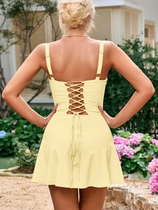 Detail of cross-back lace-up design on a slim yellow A-line dress in a garden setting
