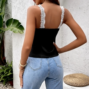 Schickes schwarzes Camisole mit breiten weißen Spitzen-Trägern und Jeanshose