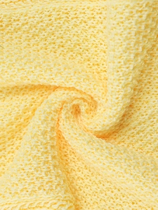 Detailed close-up of light yellow crochet knit fabric with breathable hollow mesh texture