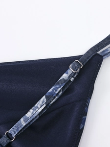 Detailed macro view of adjustable spaghetti straps and metal buckles on navy mesh dress