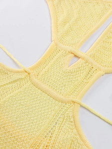 Close-up of light yellow crochet knit dress with hollow honeycomb pattern and lace-up detail