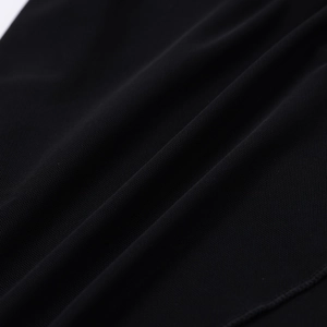 Gros plan sur un tissu en maille noire élégant montrant une texture plissée et voile doux