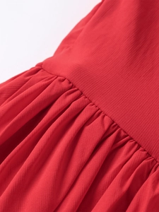 Macro view of red chiffon fabric showing intricate pleating and fine stitching details