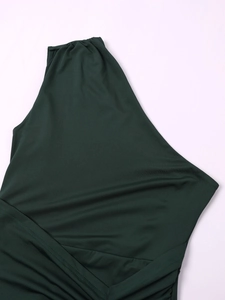 Detail of dark green one-shoulder dress showing knit fabric texture and pleated seams