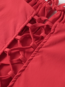 Detailed view of the red corset dress showing front lace-up tie and ribbed fabric texture