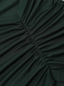 Detailed macro view of dark green ruched fabric and fine stitching on the dress