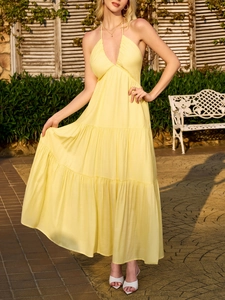 Close-up of yellow tiered halter dress with deep V-neck and delicate pleated texture