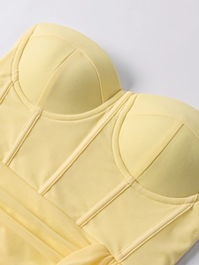 Détail de robe corset jaune avec empiècements en tulle transparent et structure baleinée