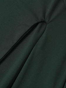 Close-up of the teardrop cutout and elegant pleated texture on the dark green dress