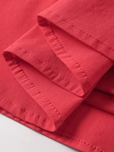 Detailed macro view of high-quality red fabric texture and neat double-needle stitching