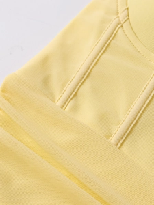 Détail du tissu en maille jaune clair avec coutures renforcées sur robe corset