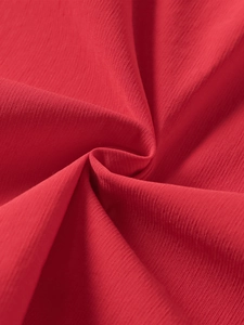 Detailed macro view of the vibrant red textured fabric on this lace-up mini dress