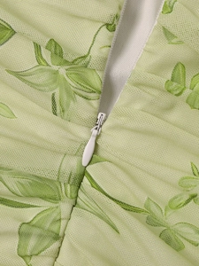 Detailed macro view of the invisible zipper and ruched mesh fabric with leaf prints
