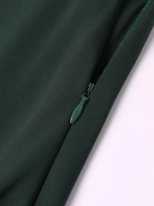 Detail of invisible teardrop zipper on dark green dress with textured fabric