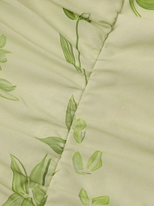 Detail of light green mesh fabric featuring leaf print and ruched stitching technique