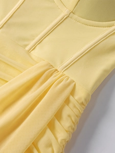 Détail d'un corset en mesh jaune clair froncé avec coutures verticales structurées