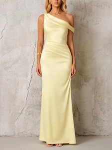 Detail of elegant one-shoulder pale yellow satin dress with waist draping and silky texture