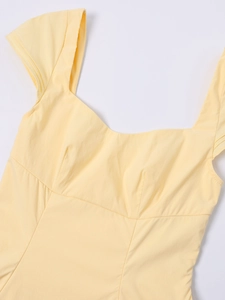 Detail of light yellow square neck dress showing fabric texture and ruched chest design