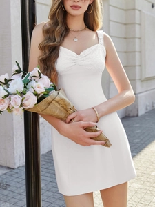Détail d'une mini robe blanche avec coutures en dentelle et design de buste froncé