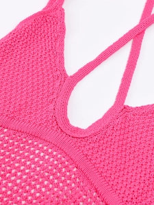 Détail d'une robe dos nu en maille rose avec des motifs ajourés en forme de losange