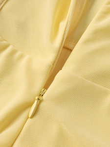 Détail de la fermeture éclair invisible sur le tissu mesh de la robe corset jaune
