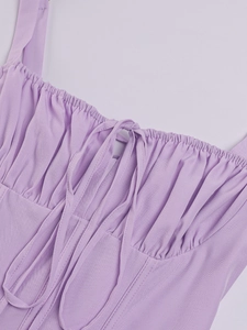 Detail of light purple dress neckline featuring pleated fabric and center tie-up strings