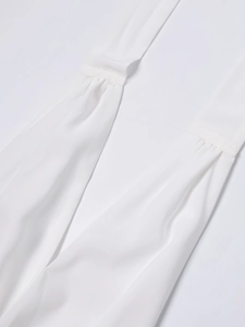 Nahaufnahme weißer Chiffon-Plissee-Details mit feinen Nähten an einem Neckholder-Kleid