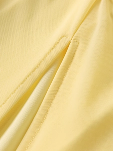 Détail de la texture en maille nid d'abeille et des coutures fines sur la robe jaune
