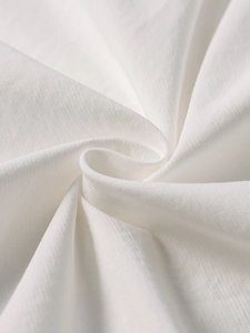 Detail shot of pure white dress fabric texture showing high-quality fine weave pattern