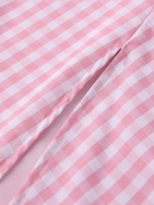 Macro shot of pink gingham dress fabric showing high-quality stitching and texture