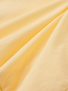 Close-up of bright yellow lightweight fabric with fine vertical texture and soft drape