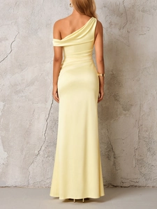 Detail view of the sleek back cut and draped satin fabric of the yellow one-shoulder gown